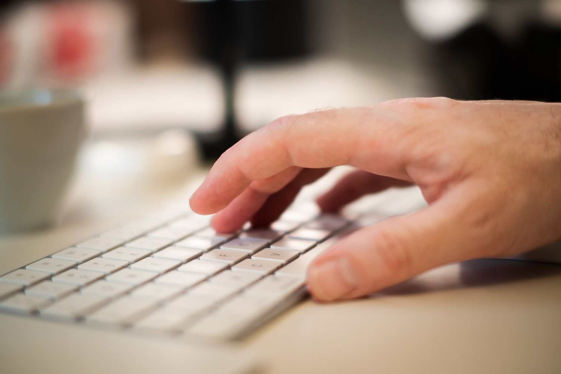 Close-up of a man typing on a keyboard, ideal for business themes.